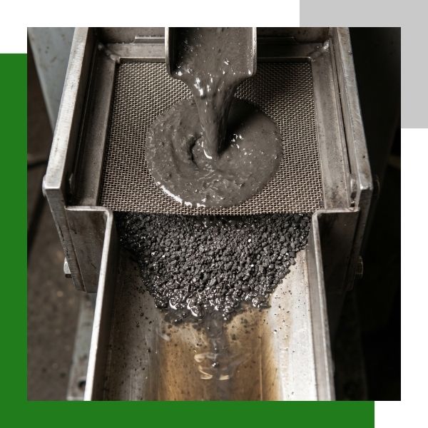 wet sludge being sifted